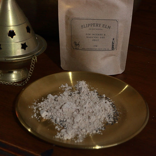slippery elm powder on a gold plate with a 'Slippery Elm' package in the background