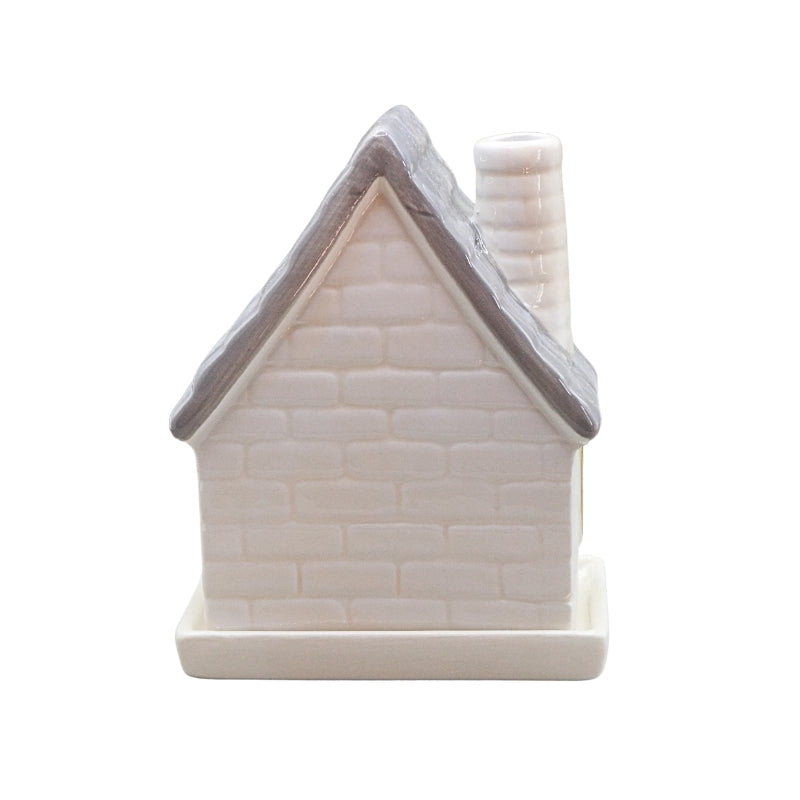 A small ceramic house-shaped container or candle holder with a textured off-white brick pattern, a gray roof, and a matching off-white chimney and base, shown on a plain white background.