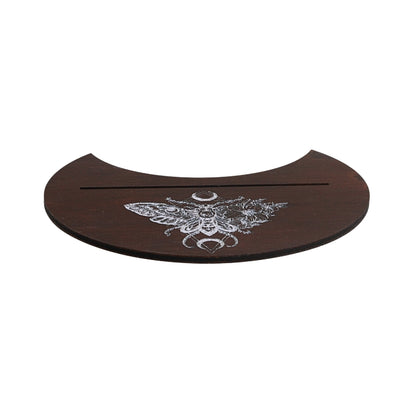 A dark brown wooden plaque with a curved top edge, featuring a white engraved moth design with a crescent moon and a horizontal slot across the center, shown on a plain white background.