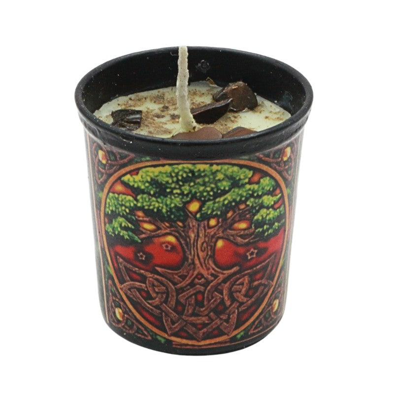 Candle in a decorative container with tree of life design on a white background