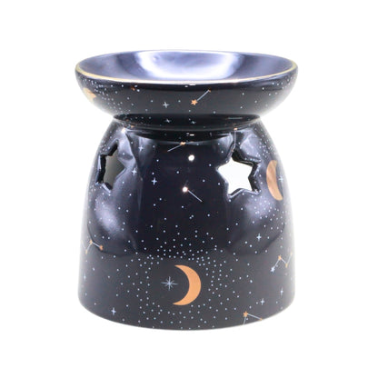 A ceramic oil burner lamp with a starry night sky design, featuring a dark blue base decorated with white stars, crescent moons, and constellations, with star-shaped cutouts on the side.
