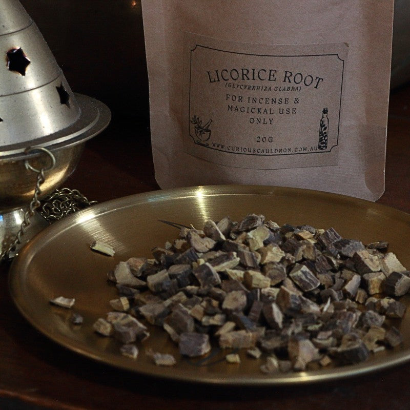 Licorice root on a metal plate with a labeled package in the background