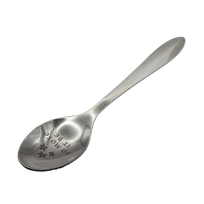 silver spoon engraved with text on white background