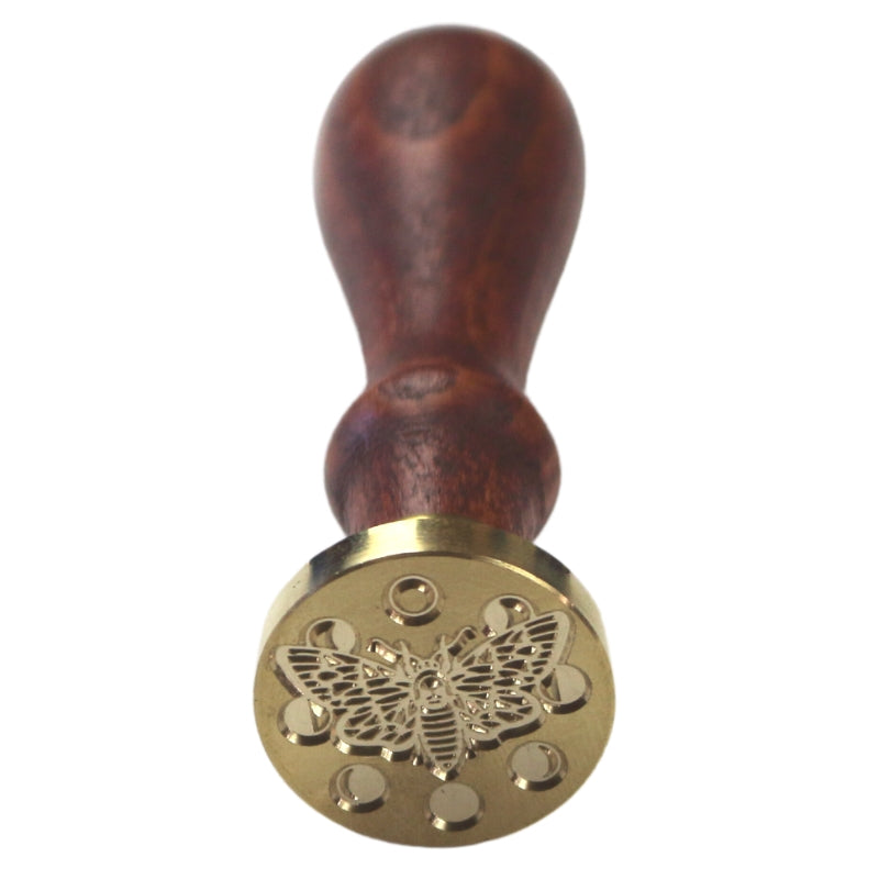 Brass wax seal stamp of a lunar moth on a wooden handle